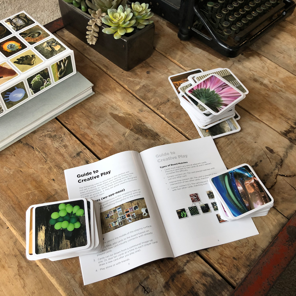 OuiSi guidebook open on coffee table, with cards all around.